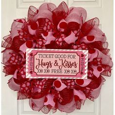 a red and pink mesh wreath with the words ticket good for hugs and kisses