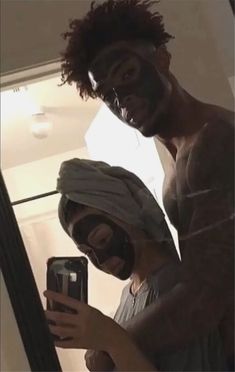 two men with face masks are taking a selfie