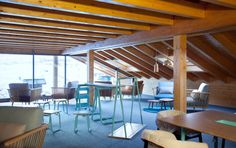 a room filled with lots of furniture and wooden beams on the ceiling, along with windows