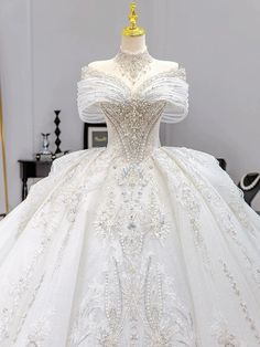 a white wedding dress on display in a room