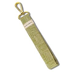 a green and white keychain with a gold metal hook on it's end