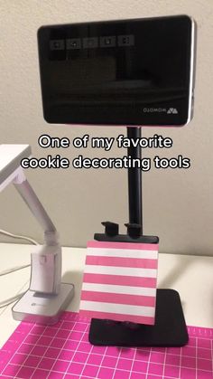 a computer desk with a pink and white flag on it, next to a cell phone