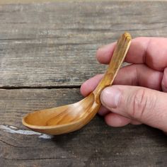 a person holding a wooden spoon in their hand