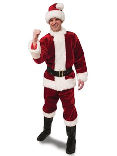 a man dressed in a santa suit and holding his fist up while posing for the camera