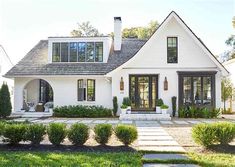 a white house with lots of windows and landscaping