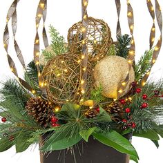 a christmas arrangement with pine cones, berries and lights