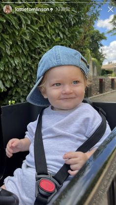 a little boy sitting in the back of a car wearing a hat