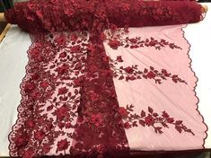 the table is covered with red lace and flowers on pink fabric, which has been cut in half