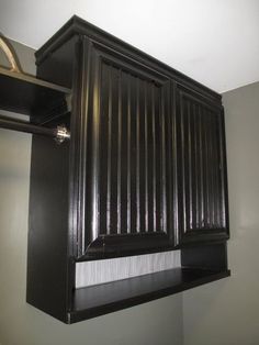 a black cabinet hanging from the ceiling in a room