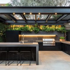 an outdoor kitchen with black cabinets and counter tops