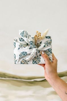 a person holding a wrapped present in their hand