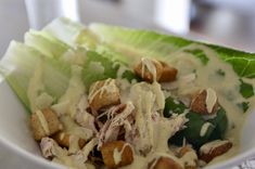 lettuce with dressing and croutons in a white bowl