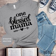 Celebrate the blessings of motherhood with our One Blessed Mama T-Shirt! This soft and comfortable unisex tee is perfect for moms who embrace their faith and family with love. Whether you're buying it for yourself or gifting it to a special mom in your life, this shirt is the perfect reminder of the beautiful blessing that motherhood brings. Key Features:  .: Soft and Durable: Made with high-quality Airlume combed and ring-spun cotton for that comfortable, all-day wear. .: Unisex Fit: The classic unisex design offers a relaxed fit, making it ideal for both casual outings and cozy moments at home.  .: Faith-Inspired Design: A perfect shirt for Christian moms, church gatherings, or family events.  .: Tear-away label for extra comfort--no annoying tags!  .: Ethically made with sweatshop-free Christian Mama Shirts, Blessed Shirts Vinyl, Family Long Sleeve T-shirt For Mother's Day, Blessed Mama Shirt, Blessed Mama, Mama T Shirt, Perfect Shirt, Unisex Design, Christian Gifts