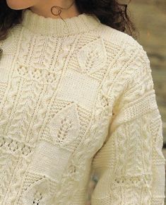 a close up of a woman wearing a white sweater