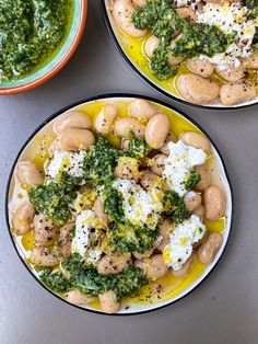 three plates filled with different types of food on top of a gray table next to bowls of pesto and eggs