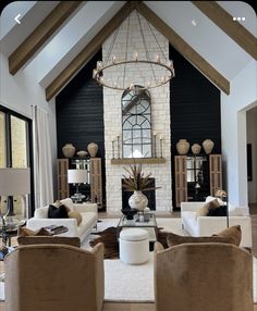 a living room with couches, chairs and a chandelier in the center