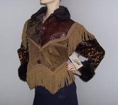 OMG!  This vintage jacket is OVER the TOP!!  A crazy patchwork melange of brocade, tapestry, tooled faux leather and velvet fabrics finished with lush faux fur collar and cuffs....then enter the 4 different kinds of trim and long boulion fringe.....I say it is just too much!  A great find for an 80's enthusiast.....it has over sized proportions with big shoulders and is cropped, comes to two points(cowgirl style) in the front.  Pair with jeggings and high rise jeans for a sassy rockabilly look.. Winter Brocade Outerwear With Long Sleeves, Long Sleeve Brocade Outerwear For Winter, Fitted Brocade Outerwear For Fall, Fall Brocade Long Sleeve Outerwear, Fall Long Sleeve Brocade Outerwear, Long Sleeve Brocade Outerwear For Fall, Rockabilly Looks, Brocade Jacket, Velvet Fabrics