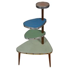 three tiered metal and wood shelf with blue, green and brown paint on the top