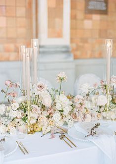 a table topped with lots of white flowers and candles