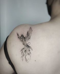 a bird tattoo on the back of a woman's shoulder