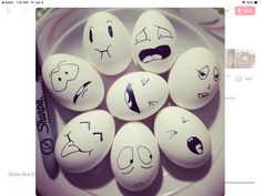 six eggs with faces drawn on them sitting in a white plate next to a marker