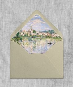 an envelope with a painting of a city on the front and water in the back