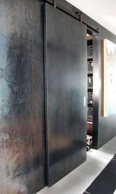 a hallway with black and white striped flooring next to a wall mounted bookcase