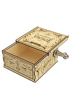 a wooden box with a key hanging from it's side and an ornate design on the lid