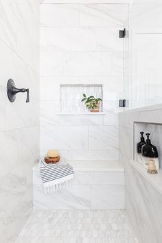 a bathroom with white marble walls and floor