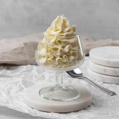 a dessert in a glass dish with whipped cream on top and spoons next to it