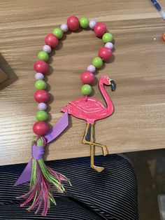 a pink flamingo beaded necklace on a table