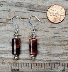 These gemstone earrings are made with Red Tiger Eye muffler shaped beads, faceted glass accent beads and lead free pewter spacers.   The Red Tiger Eye beads are 0.65 inches long, 0.25 inches wide, and 0.15 inches thick.  The earrings are available with silver or gold findings:  we make them with either gold or silver color pewter spacers and gold or silver plated headpins. The earwires on the earrings as pictured are silver plated brass hooks, nickel free and hypoallergenic for sensitive ears. Nickel-free Rectangular Czech Glass Jewelry, Nickel-free Brown Czech Glass Jewelry, Brown Faceted Beads Dangle Jewelry, Adjustable Czech Glass Earrings With Faceted Beads, Faceted Czech Glass Dangle Jewelry, Hypoallergenic Czech Glass Dangle Crystal Earrings, Czech Glass Faceted Earrings For Gifts, Faceted Czech Glass Earrings As Gift, Brass Hooks