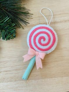 a lollipop ornament hanging from a christmas tree on a wooden table