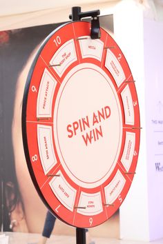 a spin and win board on display in a room with a woman walking past it