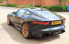 a black sports car parked in front of a brick building