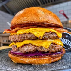 a cheeseburger with bacon and onions on a marble platter in a restaurant