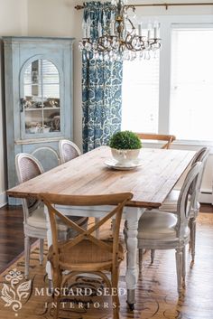 a dining room table and chairs in front of a window