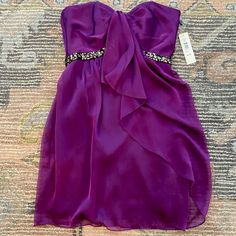 New With Tags Purple Cocktail Dress With Sequin Detailing. Size 4. Chic Holiday Strapless Dress For Cocktail, Elegant Strapless Dress For Formal Holiday, Elegant Strapless Dress For Holiday Formals, Elegant Strapless Dress For Holiday Formal Events, Elegant Purple Strapless Dress For Night Out, Elegant Strapless Cocktail Dress For Holidays, Elegant Purple Strapless Dress For Date Night, Purple Mini Length Strapless Dress For Cocktail, Purple Embellished Strapless Dress