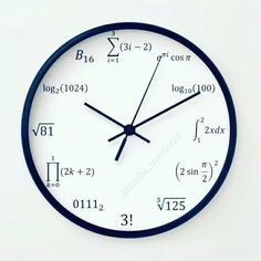 a clock with numbers and symbols on the face is in front of a white wall