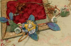 an arrangement of flowers and other items on a table cloth with gold sequins