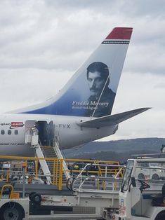 an airplane is being loaded with luggage by a man on the stairs and in front of it