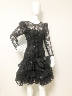 This is a black party dress from After Five. The dress has lace puff sleeves, a low cut v back neckline, lace overlay, sequins and tulle. If that wasn't enough, it also has a big satin 80's bow at the drop waist that is embellished with rhinestones. All the 80's bells and whistles are included with this one. Size tag 6. Check measurements carefully, no stretch. No flaws noted. Measurements taken with dress laying flat and doubled where appropriate. We recommend comparing measurements with an ite Embellished Black Dress, Dress Low Back, Low Back Dress, Black Party Dress, Low Back Dresses, Beaded Jacket, Black Party Dresses, Blazer Designs, Black Party