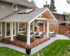 an outdoor living area with couches and chairs on the deck in front of a house