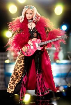 a barbie doll dressed in red and black holding a guitar on stage with lights behind her