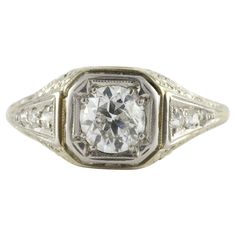 an old - fashioned diamond ring with two diamonds in the center and side stones on each side