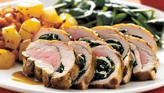 sliced pork with spinach and potatoes on a plate