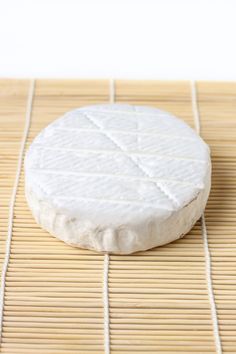 a piece of cheese sitting on top of a bamboo mat