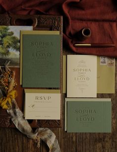 the wedding stationery is laid out neatly on top of the wooden table, along with other items