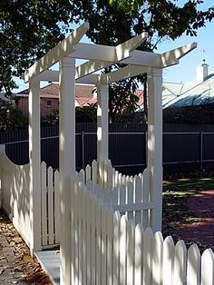 a white picket fence next to a tree