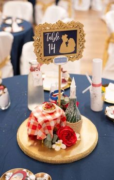 a table topped with plates and trays filled with food next to tables covered in blue linen